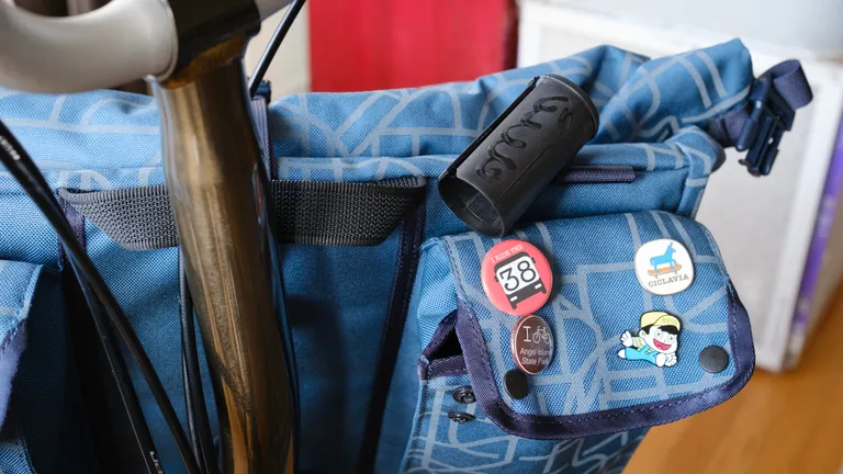 A black nylon sleeve with glue residue on top of a blue bag.