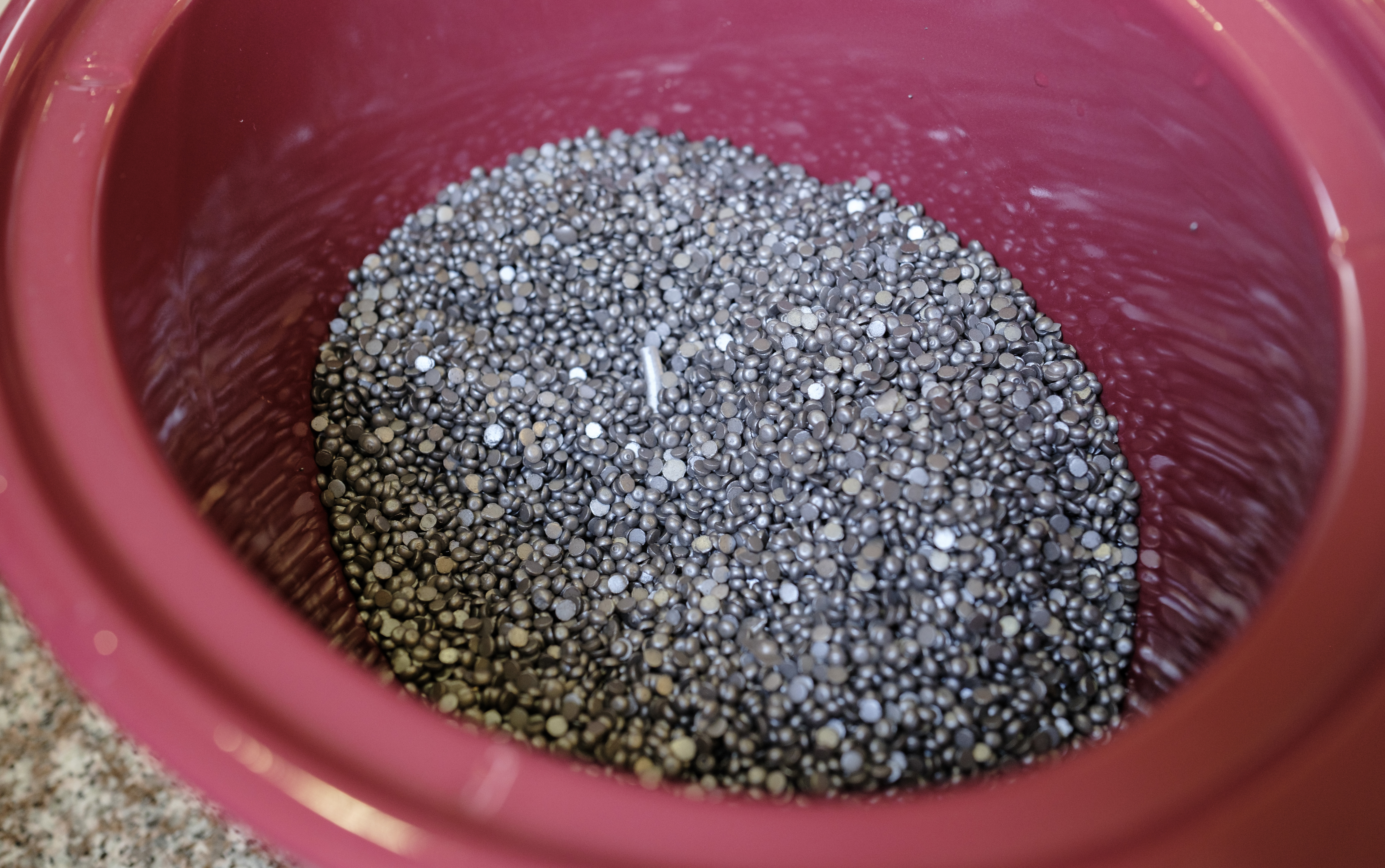 Hundreds of wax pellets sitting in a slow cooker