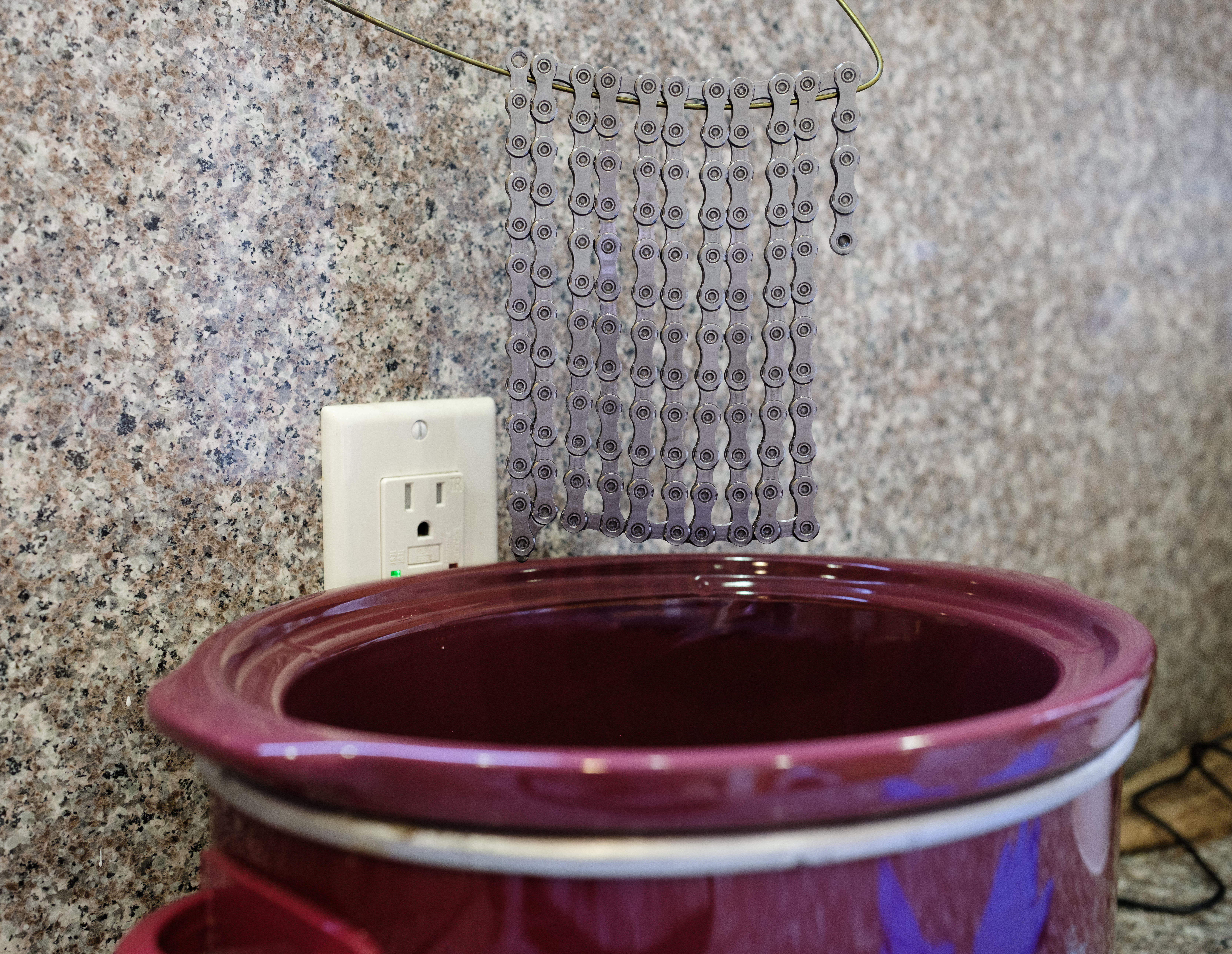A close up view of the chain suspended over the slow cooker