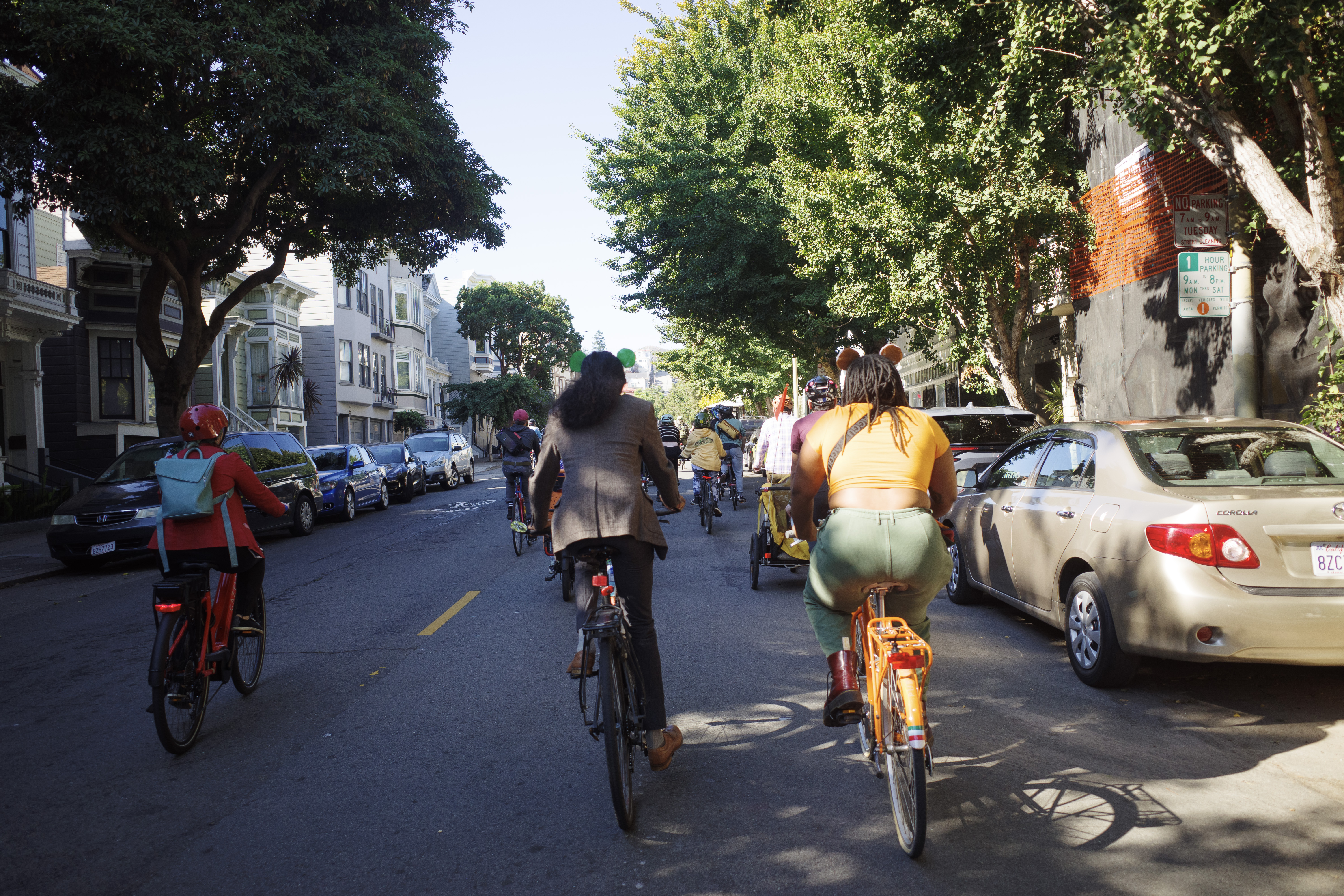 Two cyclists riding in Frog and Toad costumes.