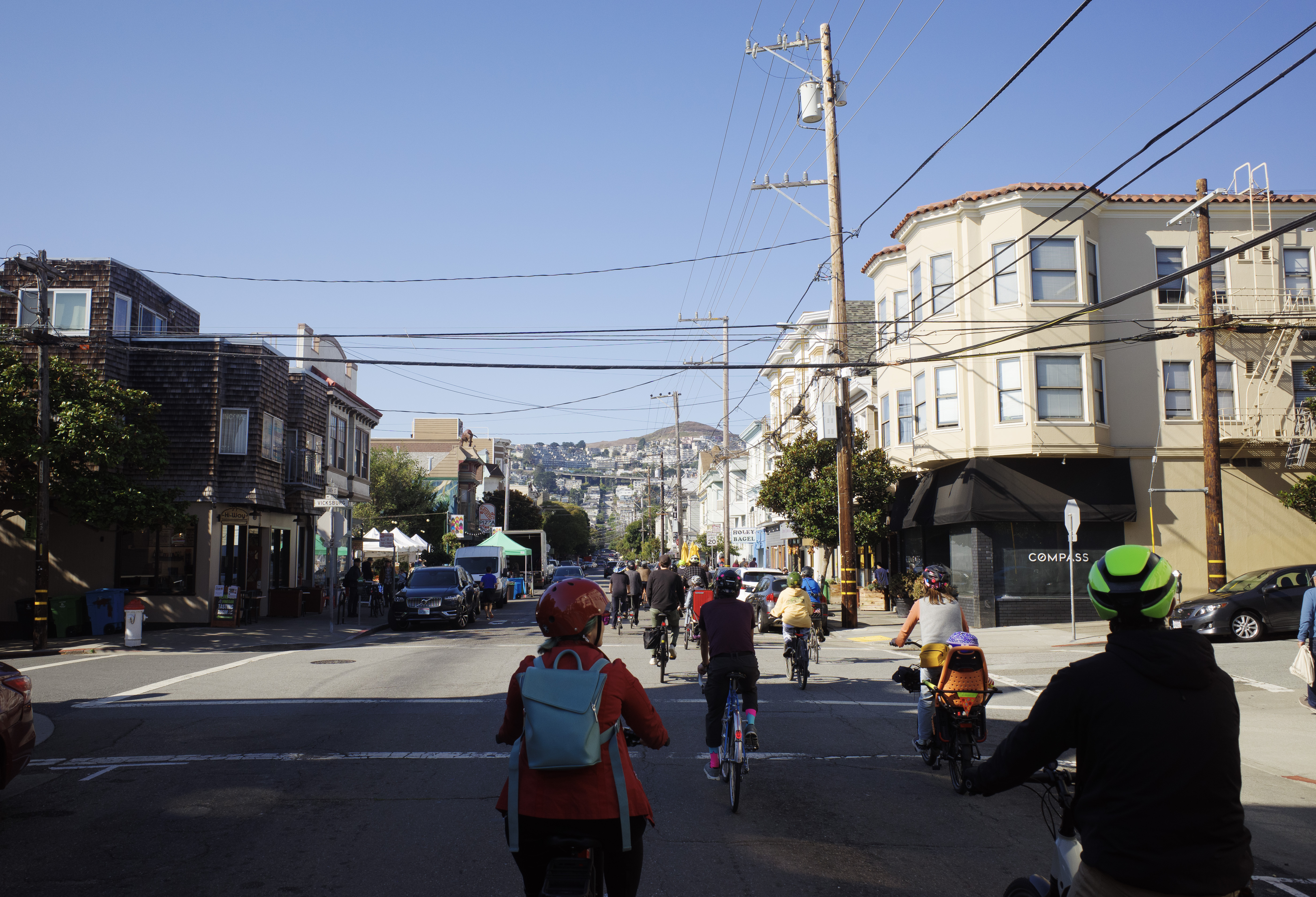 A group of cyclists crossing 24th & Vicksburg facing Twin Peaks
