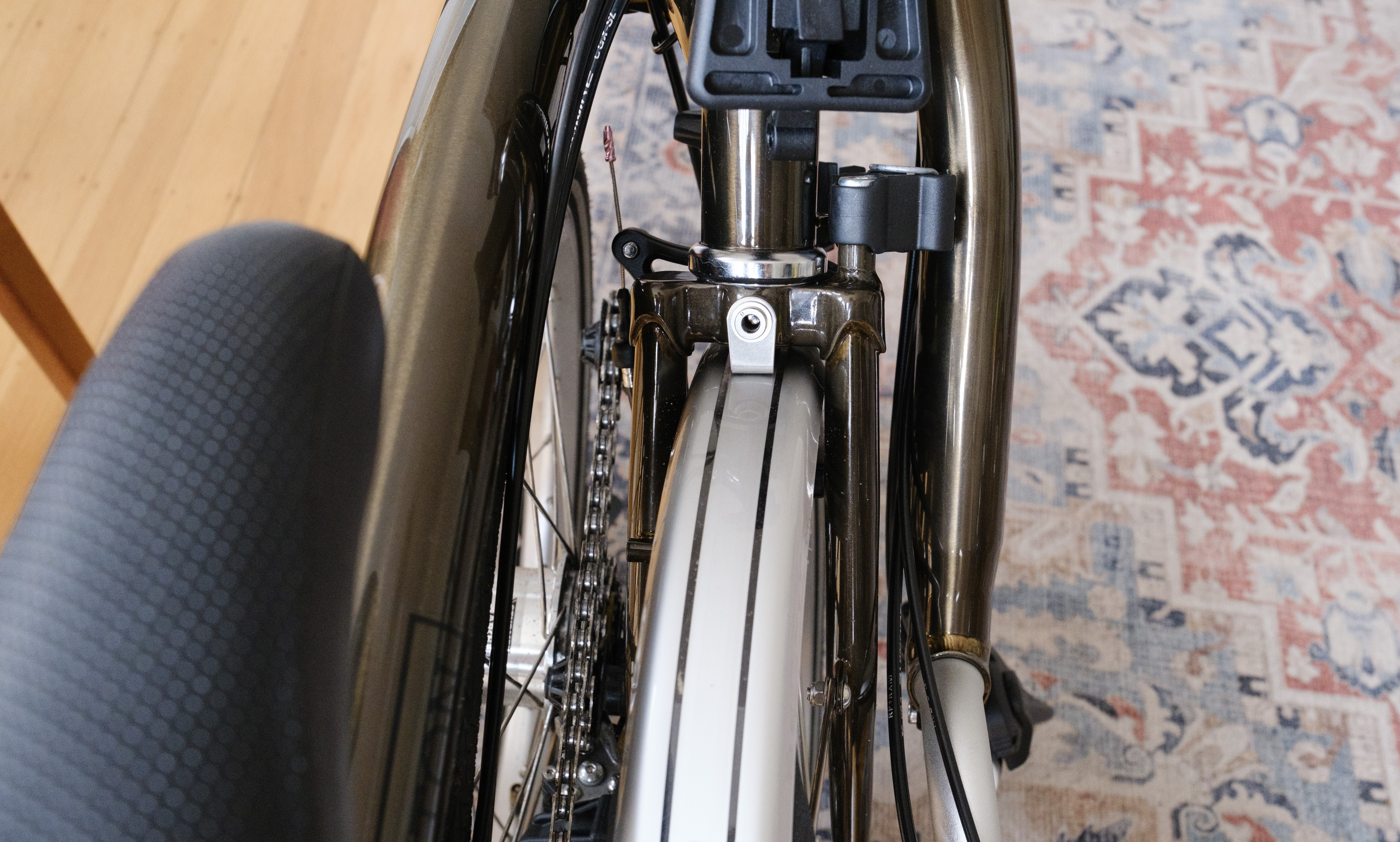 Looking above at a folded Brompton showing the stem hinged down with its nipple in the handlebar catch.