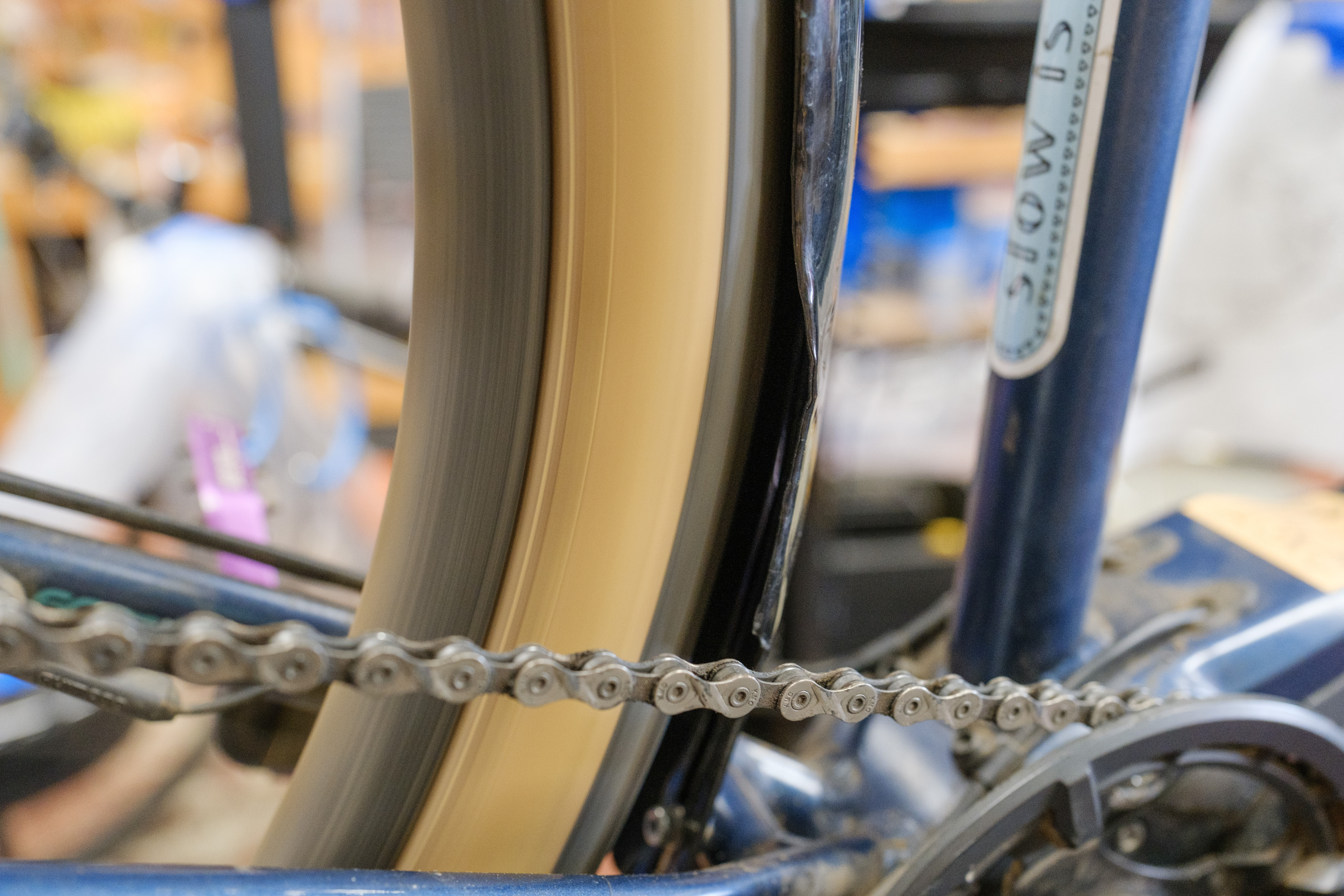 A close up of a fender edge that has been warped with heat. A bike wheel is spinning