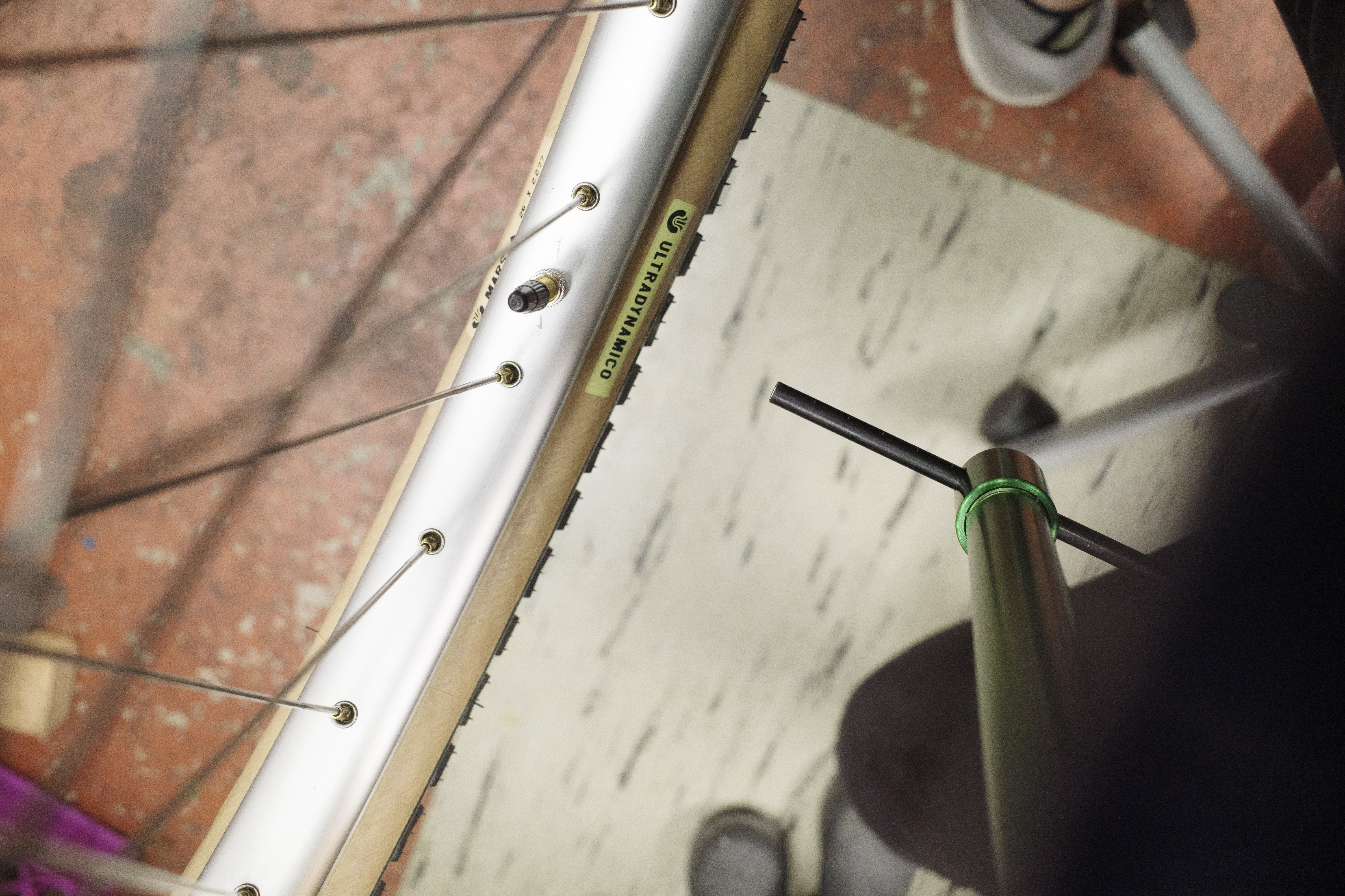 A couple inch gap between a derailleur hanger alignment gauge and the rim of a rear wheel.