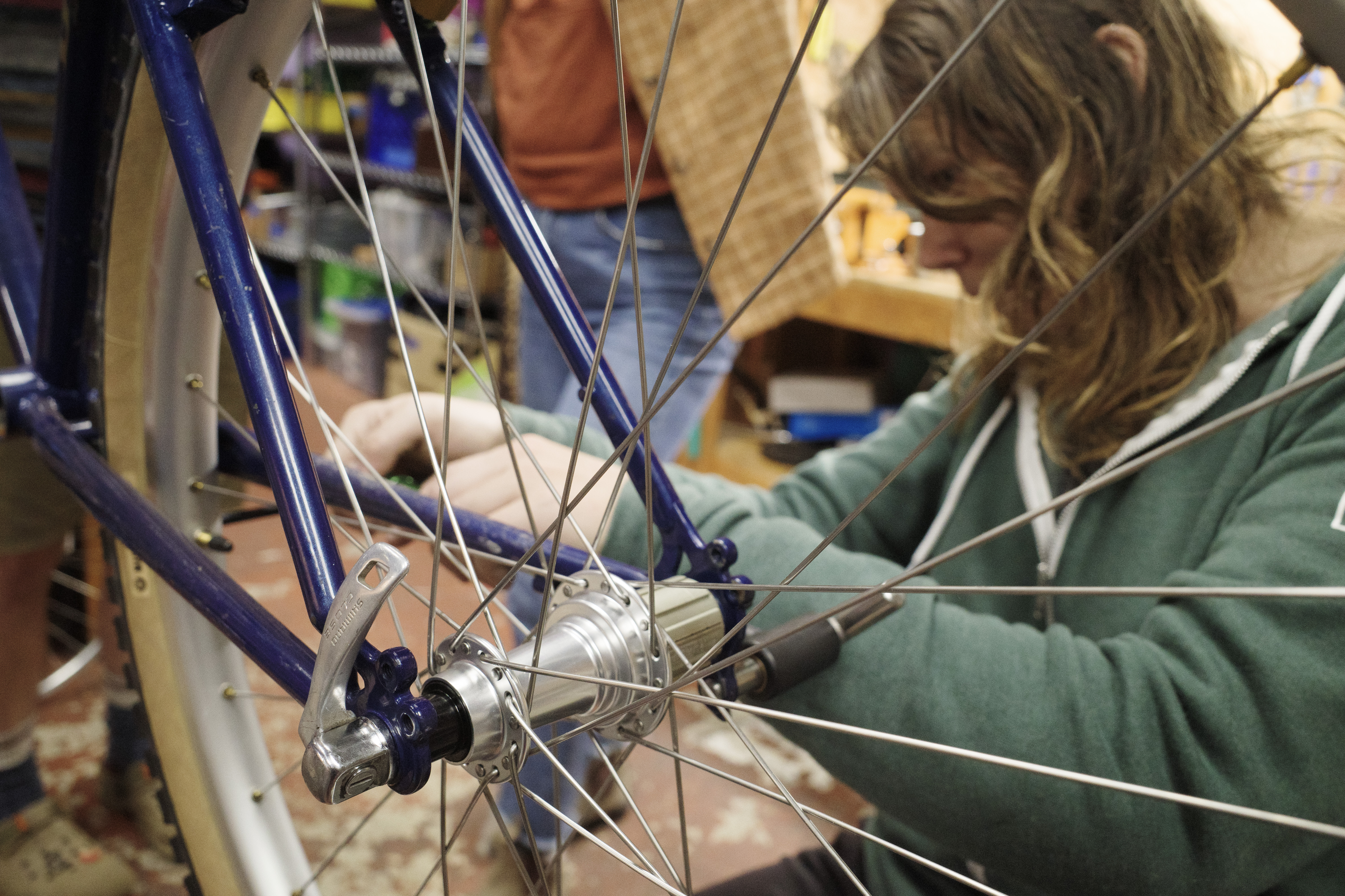 A close up of the rear hub and rear triangle with me out of focus bending the derailleur hanger