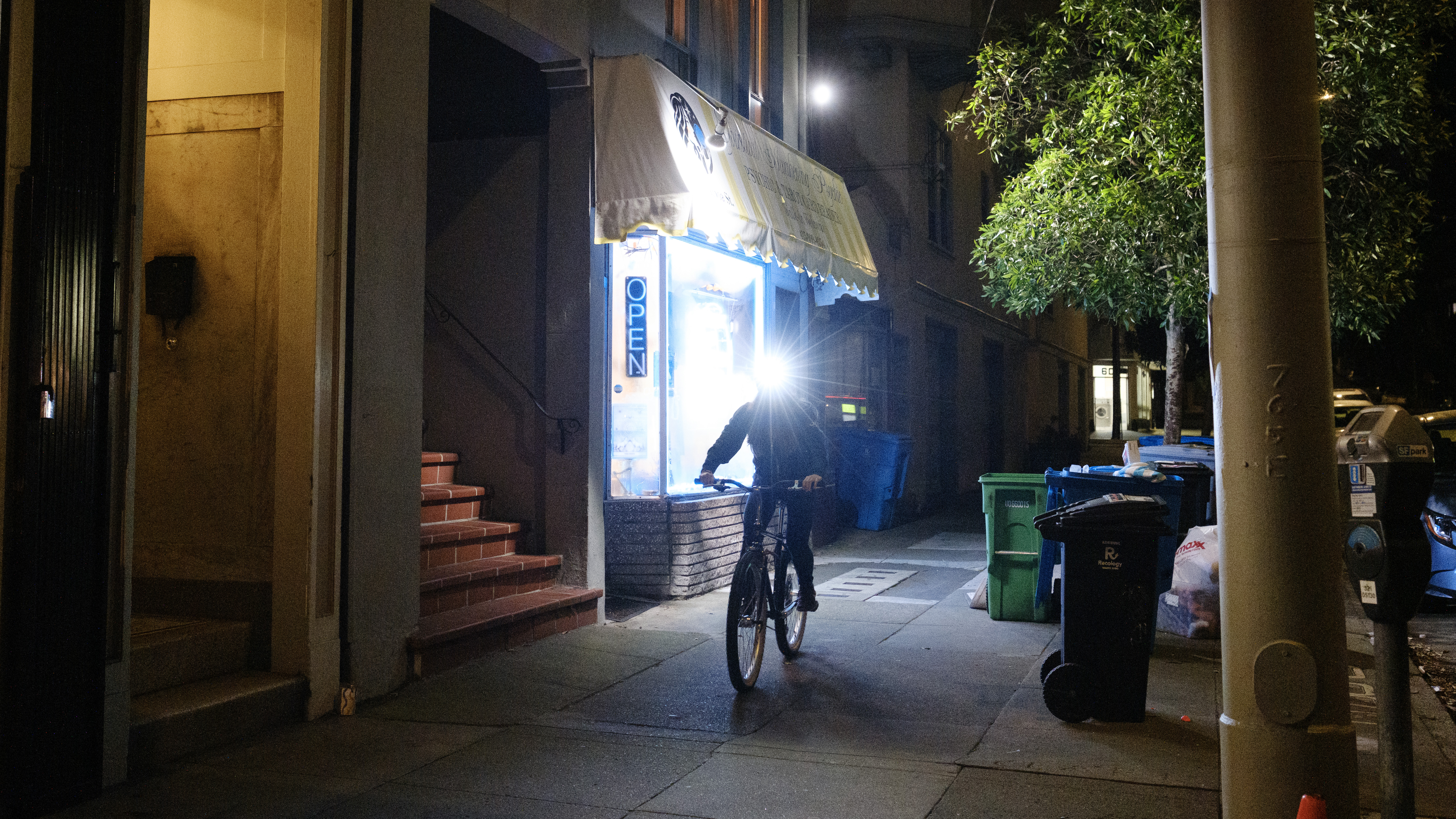 Kat riding her bike towards the camera with a headlamp on.