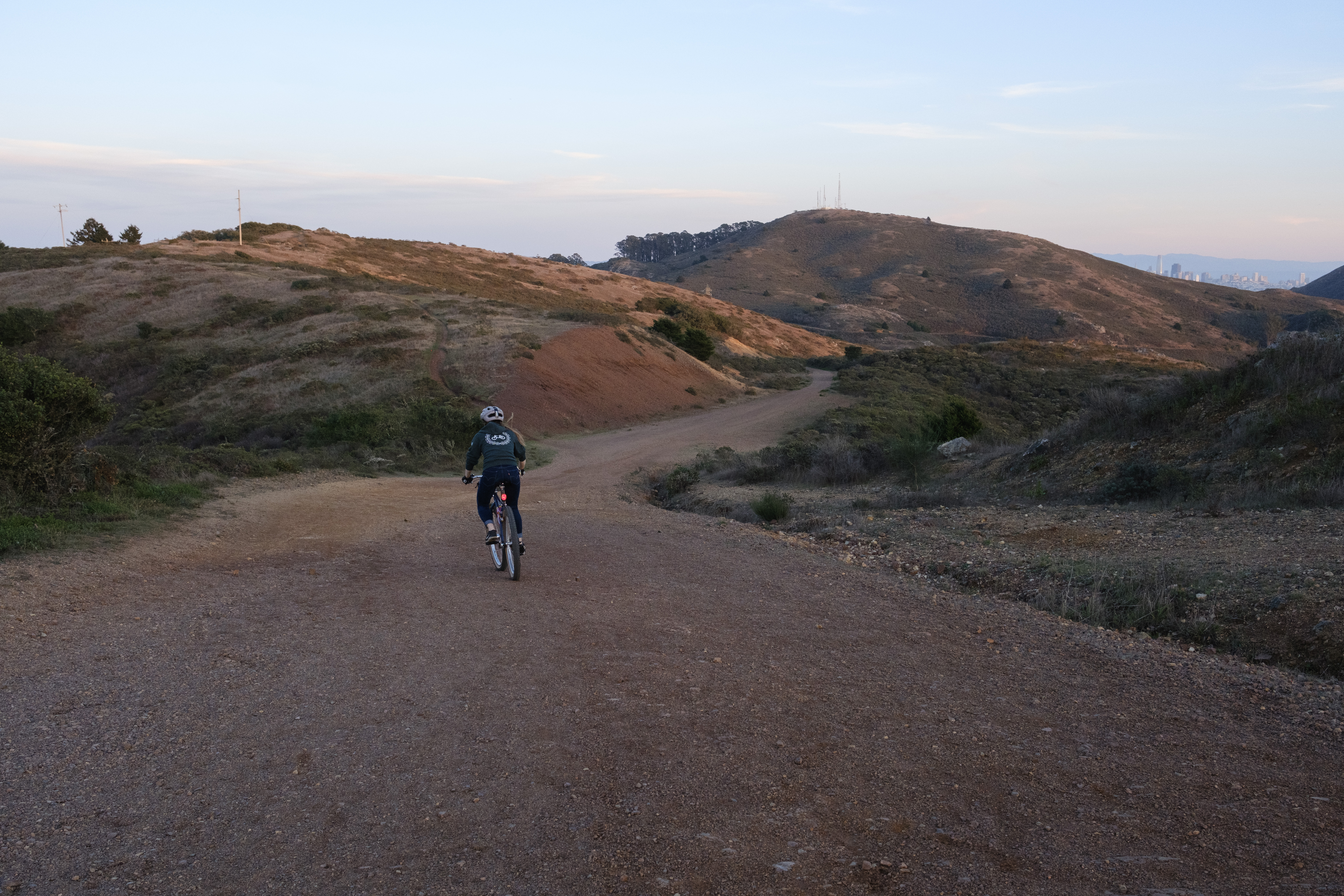 Kat on her bike descending back towards the valley. The San Francisco skyline is visible in the background.