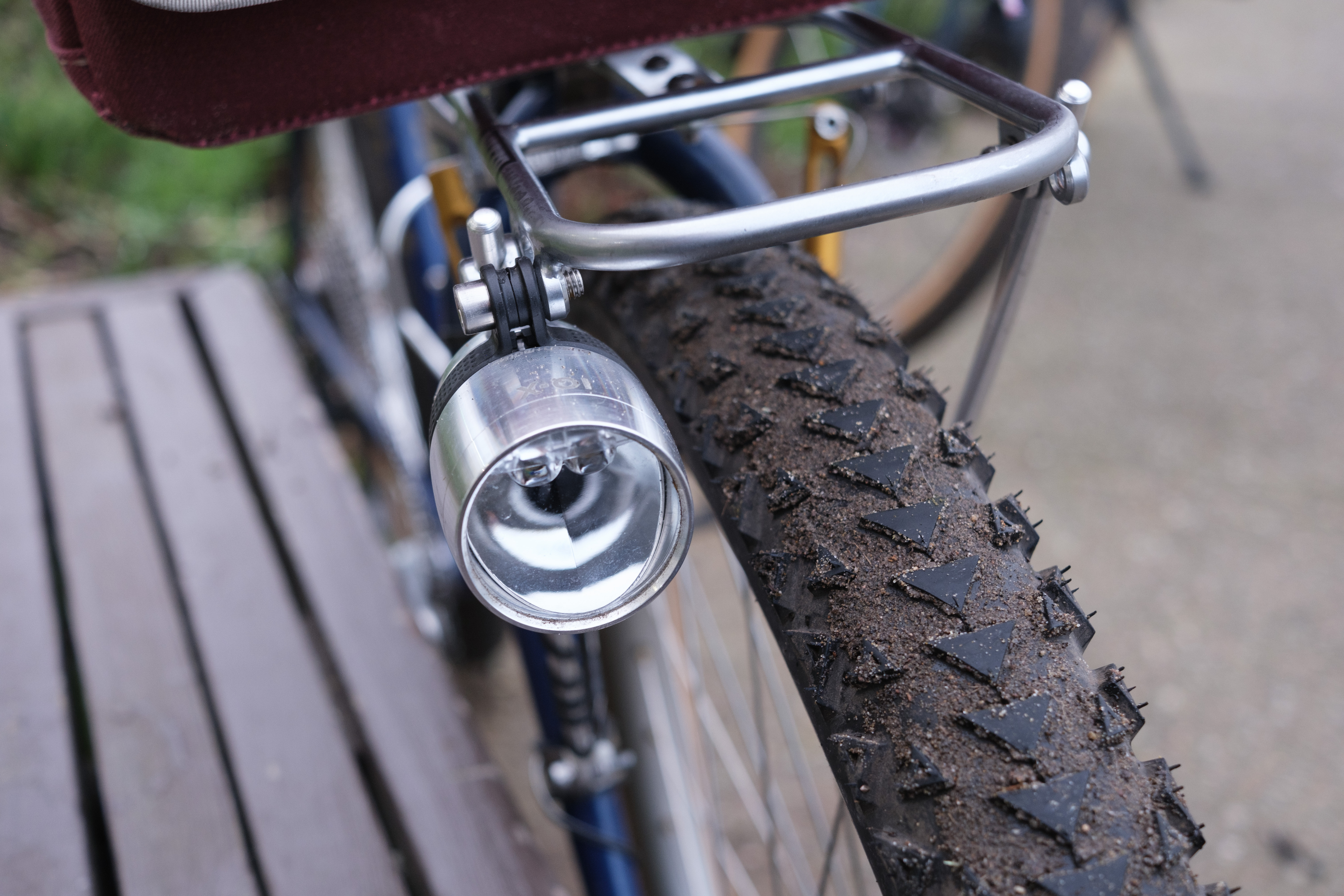 An IQ-X front dynamo light mounted to a dull silver rack.