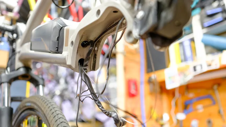 The motor cabinet of a mid-drive e-bike with various loose cables coming from the downtube and chainstay