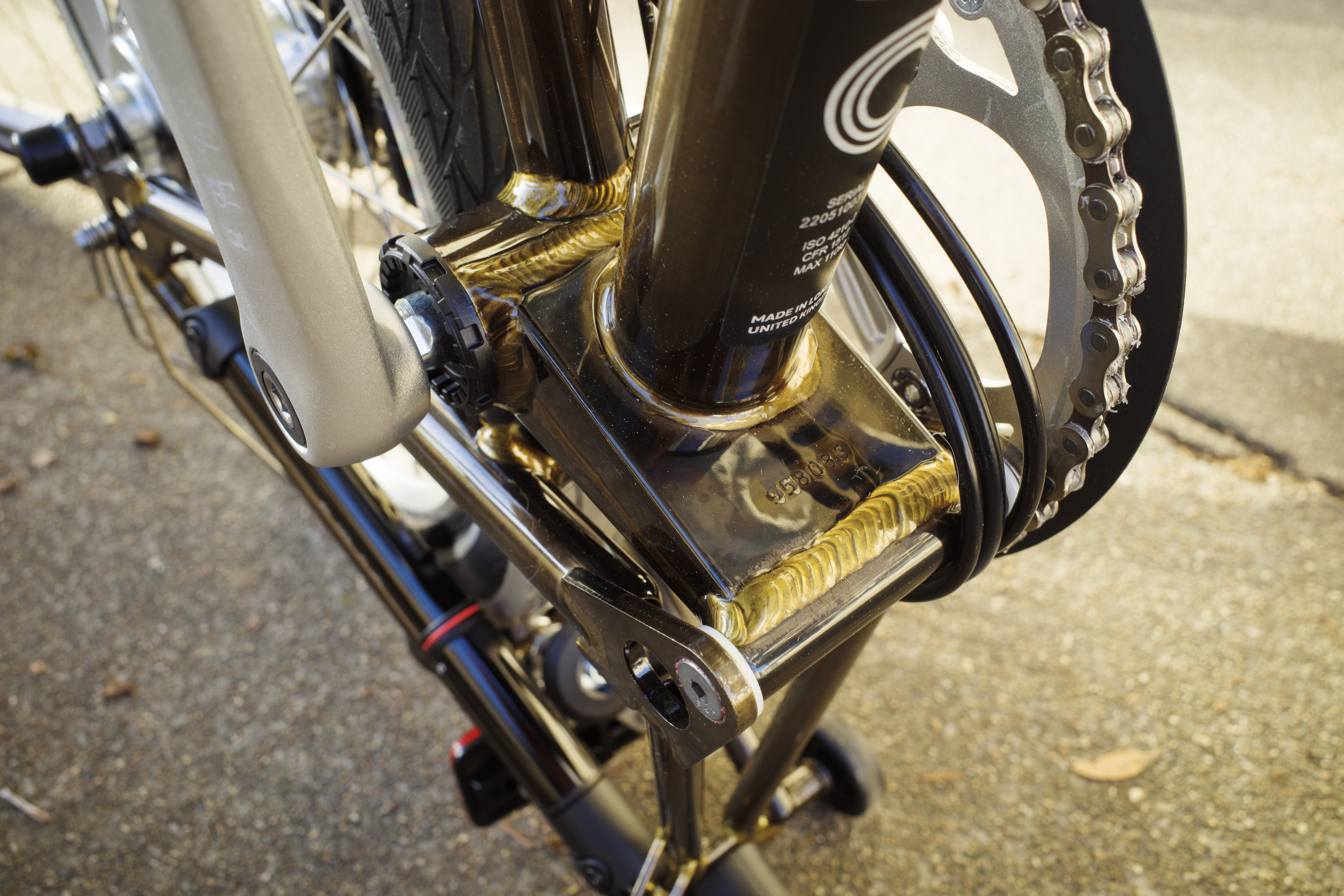 The brazing showing through the transparent lacquered finish on the Brompton's seat tube bottom.