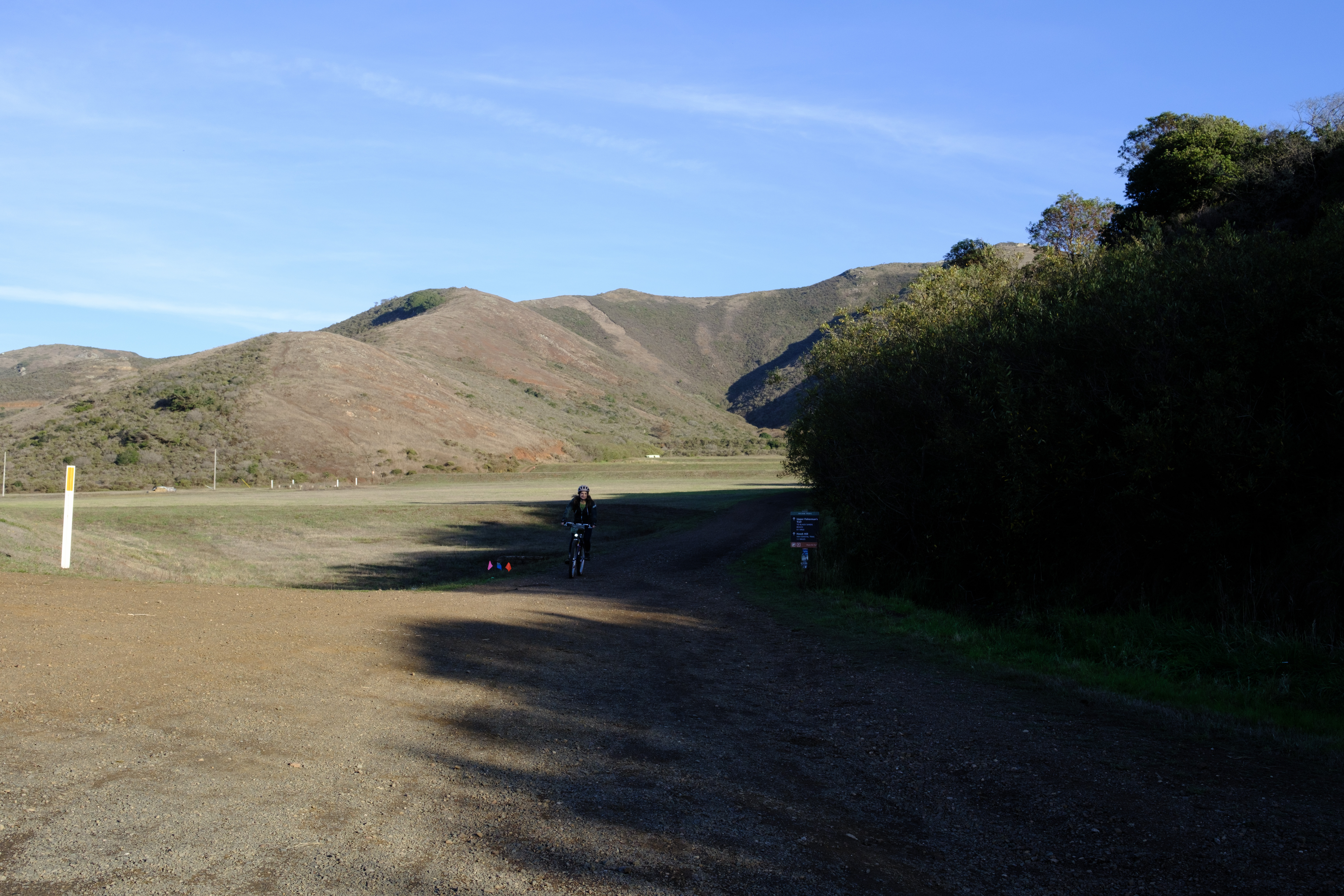 Kat coming down from Julian Trail. The right half of the image is in shadow from the ridge and the left half is still lit by the low sun