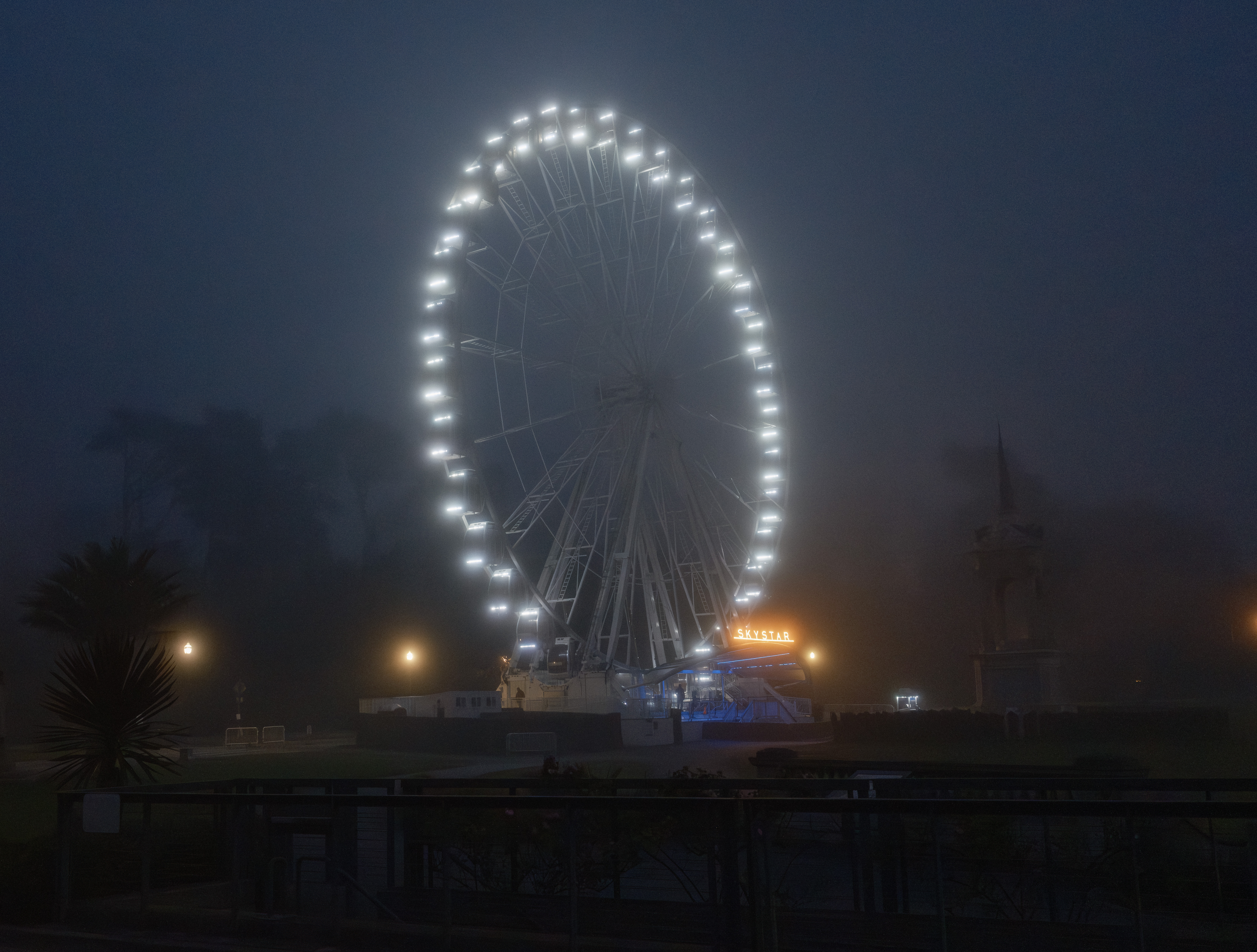 The Skystar ferris wheel glowing in the fog.