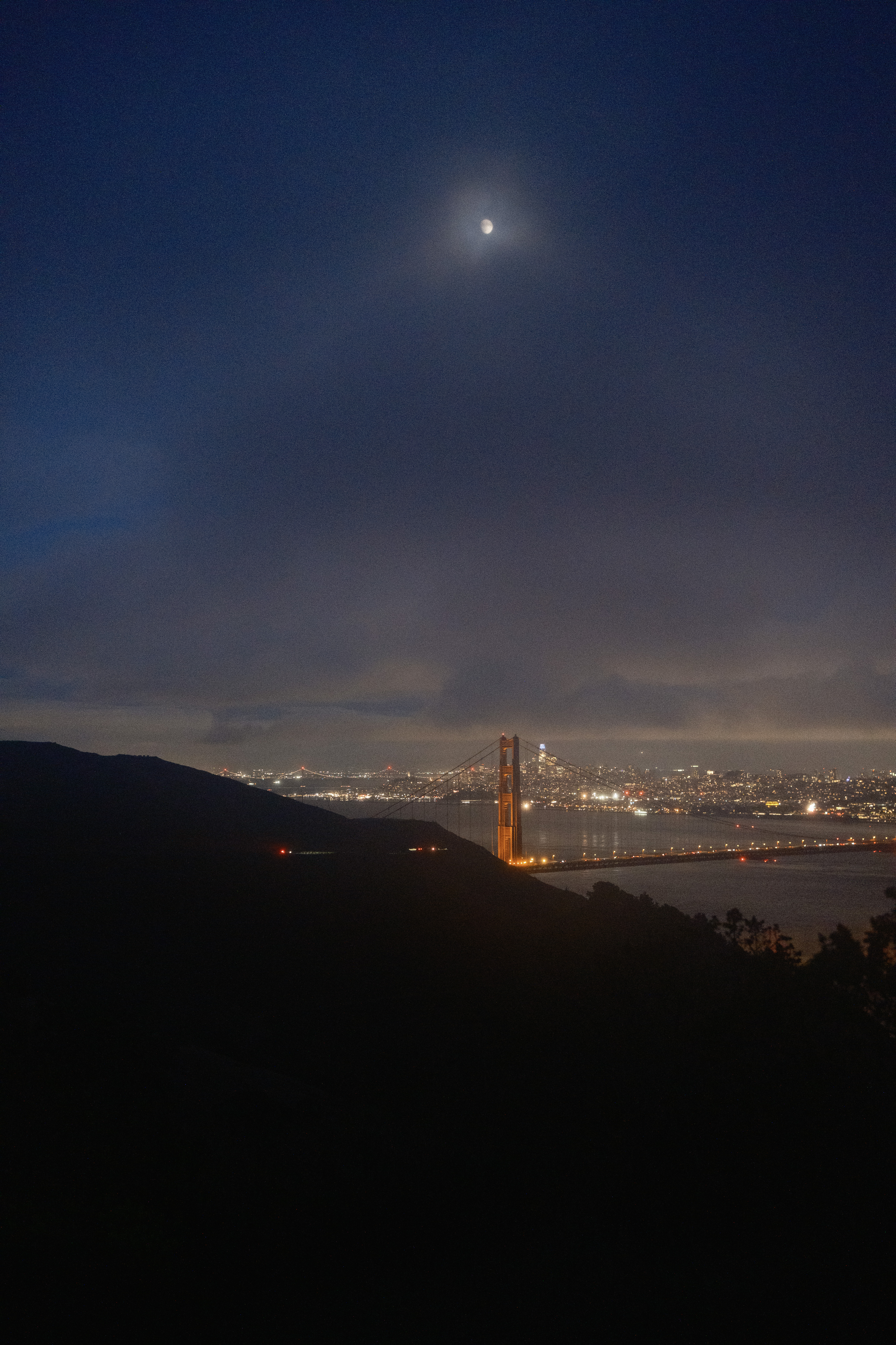 The moon over the Golden Gate Bridge and Salesforce tower.
